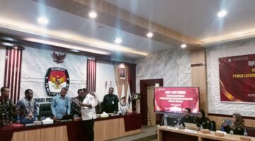 Ketua KPU Fakfak Hendra J.C Talla menyerahkan salinan Keputusan KPU Nomor 3 Tahun 2026 tentang Penetapan Rekapitulasi Data Pemilih Berkelanjutan Kabupaten Fakfak kepada salah satu unsur pimpinan Bawaslu Kabupaten Fakfak.